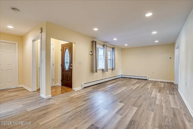 a view of empty room with wooden floor
