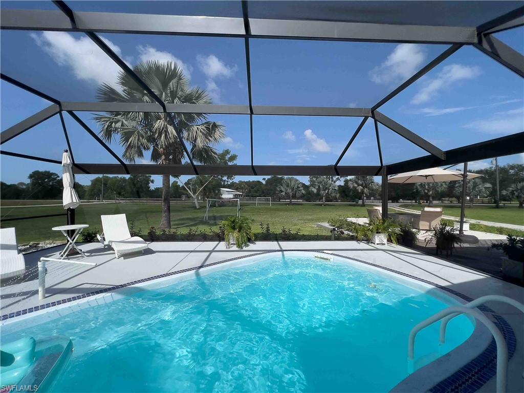 3220 63rd Street Southwest Naples, FL 34105 - Photo 14 of 36 Swimming pool with a lawn, a patio, and glass enclosure