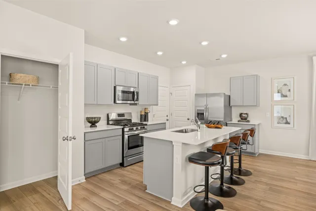 a kitchen with a sink stainless steel appliances and white cabinets