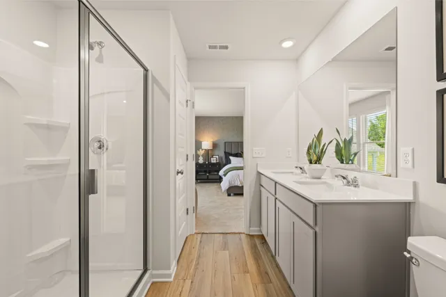 a bathroom with a toilet a sink a mirror a bathtub and vanity