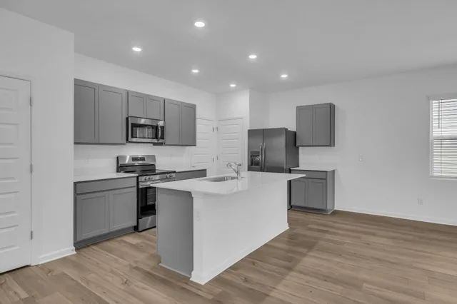 a kitchen with a sink a counter top space stainless steel appliances and cabinets