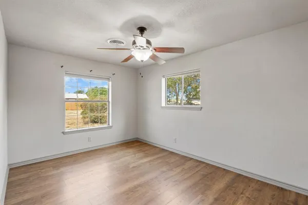 a view of an empty room with wooden floor