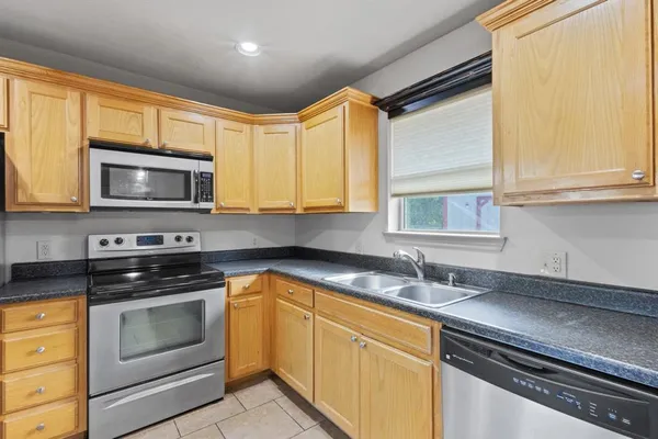 a kitchen with granite countertop a sink stainless steel appliances and cabinets