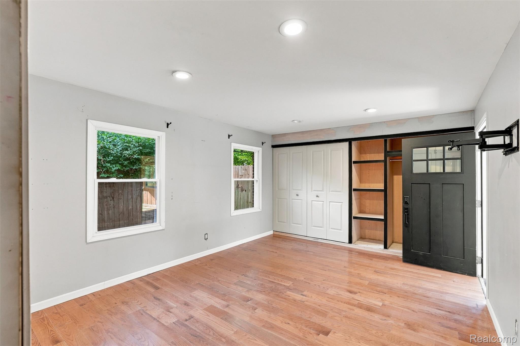 17620 Cornell Road Southfield, MI 48075 - Photo 16 of 29 Hardwood-style flooring, recessed lighting, double-pane windows, built-in shelving, and a sliding barn door with glass inserts