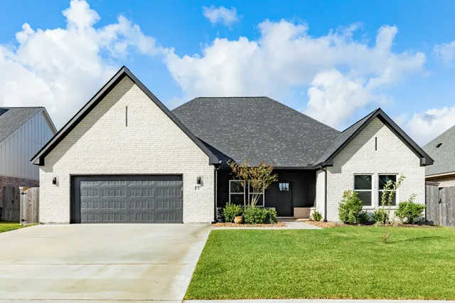 a front view of a house with a yard garden and outdoor seating
