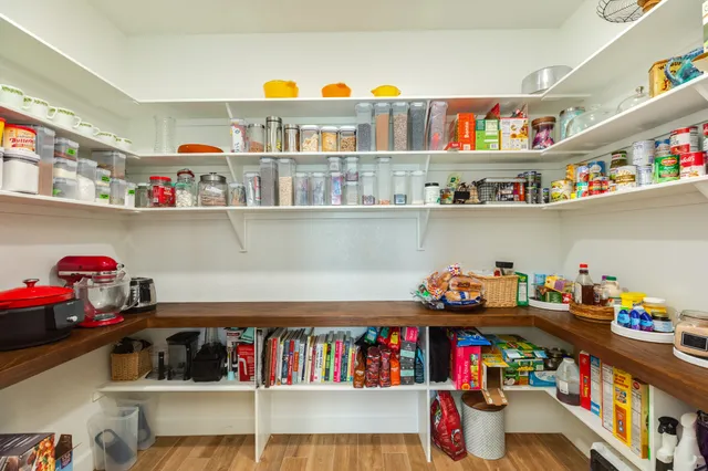 a utility room with lots of clutter and white cabinets