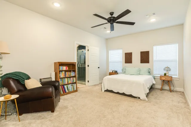 a spacious bedroom with a bed a couch and a bookshelf
