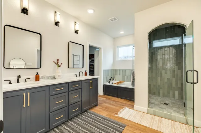 a bathroom with a double vanity sink mirror and shower