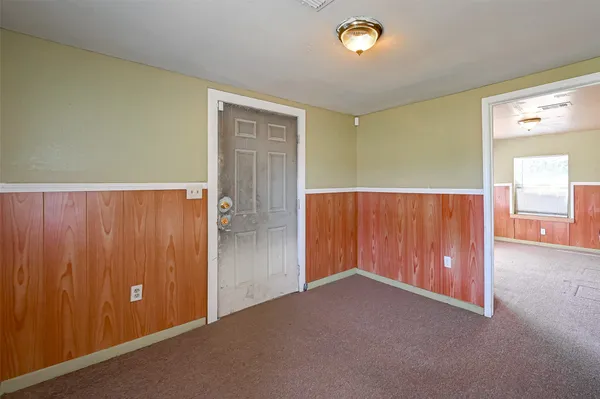 an empty room with windows & cabinet