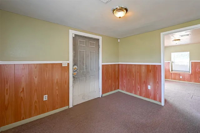 an empty room with windows & cabinet