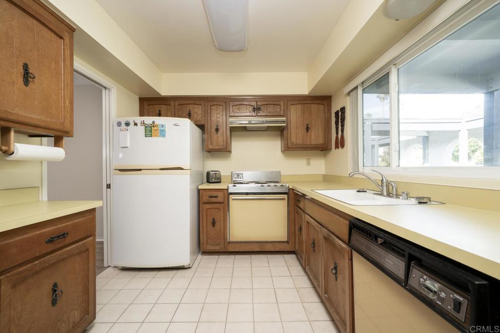3606 Vista Rey, Unit 46 Oceanside, CA 92057 - Photo 10 of 32 a kitchen with a sink a refrigerator and a stove