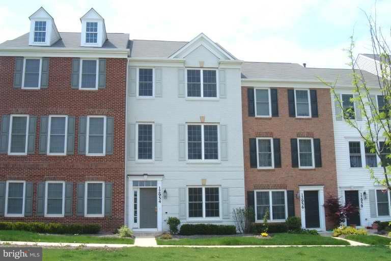 a front view of a building with yard and windows