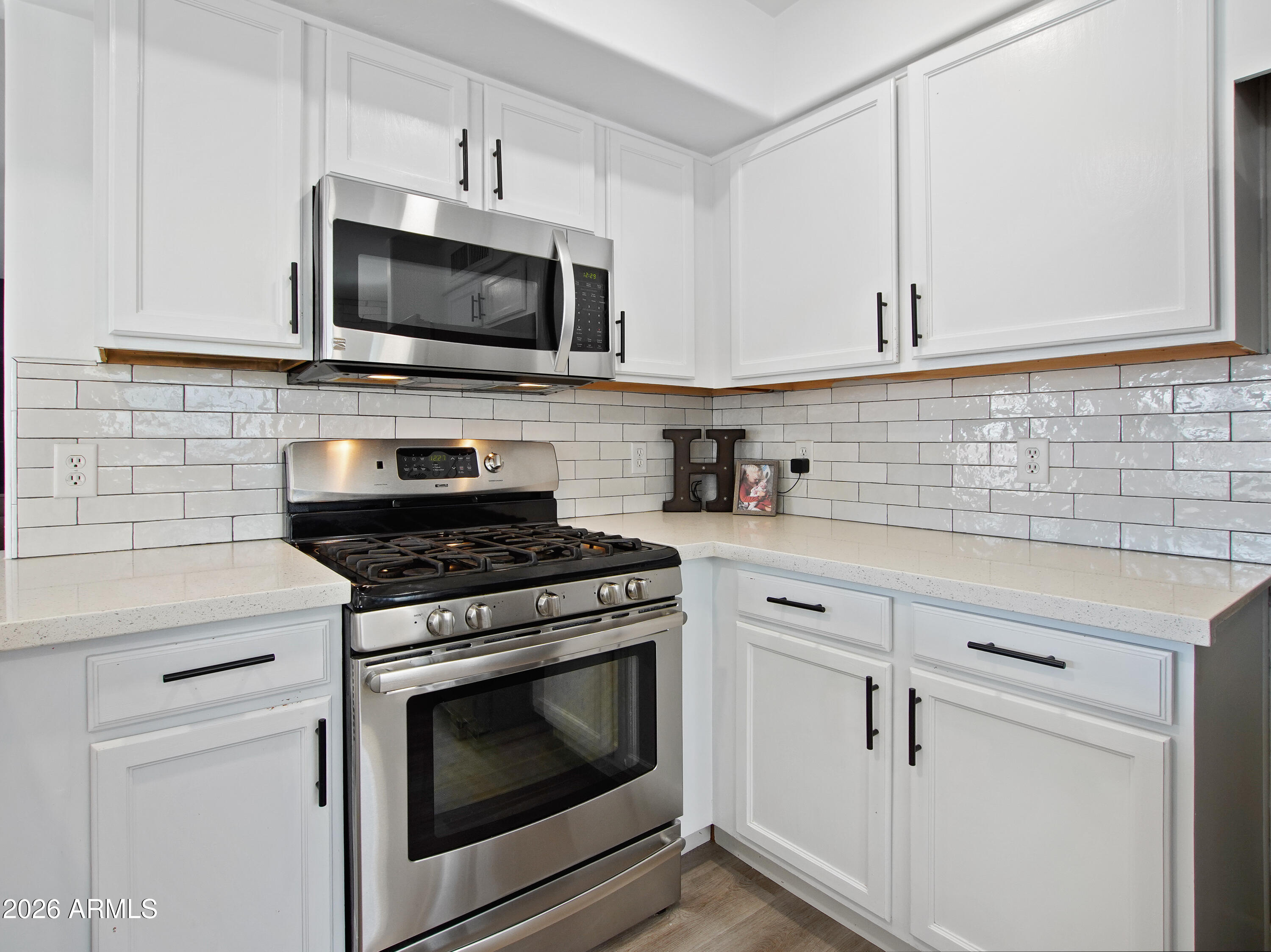 1960 South Portland Court Gilbert, AZ 85295 - Photo 20 of 53 a kitchen with stainless steel appliances white cabinets and a stove top oven