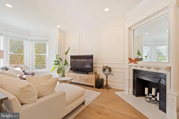a view of a livingroom with a fireplace window and wooden floor