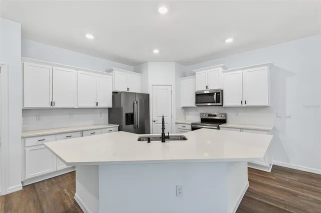 a kitchen with stainless steel appliances a sink a stove a microwave and cabinets