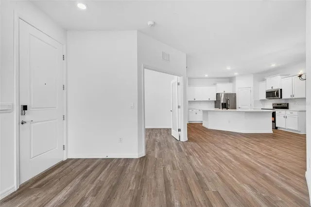 a view of a kitchen with kitchen island a sink stainless steel appliances and cabinets
