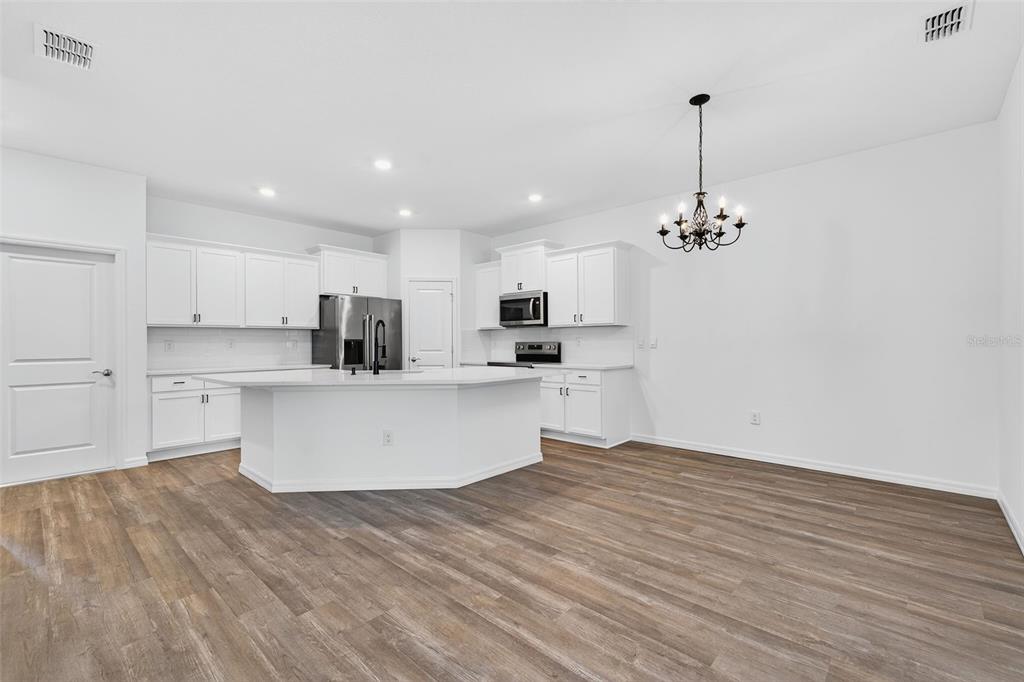 31463 Paper Birch Street Wesley Chapel, FL 33545 - Photo 16 of 40 a view of a kitchen with kitchen island a sink stainless steel appliances and cabinets