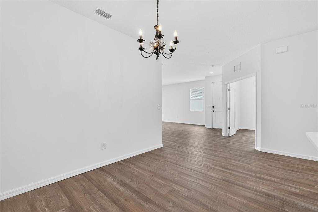 31463 Paper Birch Street Wesley Chapel, FL 33545 - Photo 17 of 40 a view of a chandelier in big room with wooden floor
