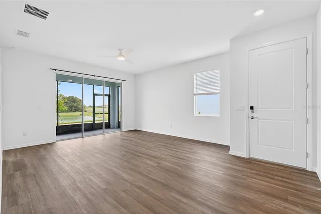 a view of empty room with wooden floor and window