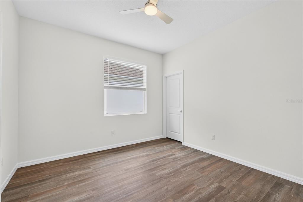 31463 Paper Birch Street Wesley Chapel, FL 33545 - Photo 22 of 40 an empty room with wooden floor and windows