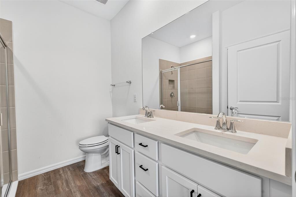 31463 Paper Birch Street Wesley Chapel, FL 33545 - Photo 27 of 40 a bathroom with a granite countertop sink a toilet and a mirror
