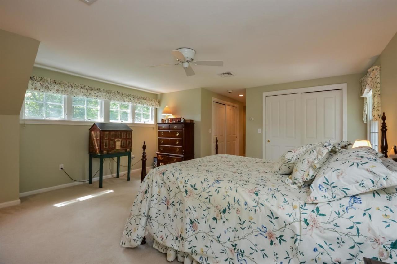 164 Scudder Road Osterville, MA 02655 - Photo 11 of 30 a bedroom with a bed and a chandelier