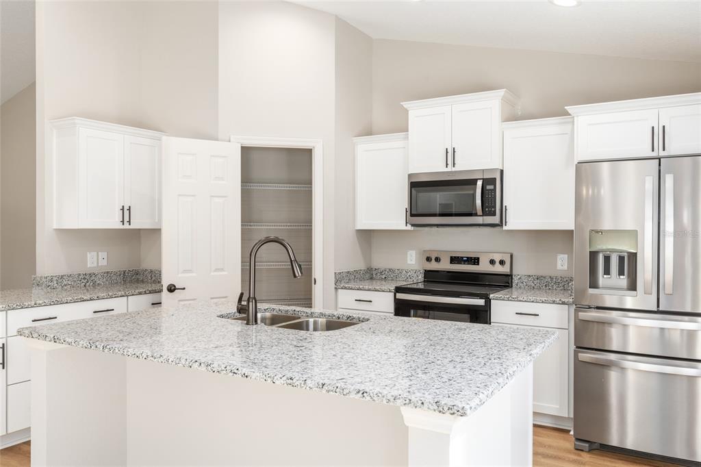 5796 Southwest 124th Ter Road Ocala, FL 34481 - Photo 16 of 63 a kitchen with stainless steel appliances granite countertop a stove a sink a refrigerator a microwave and white cabinets