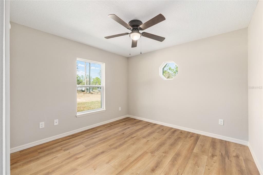 5796 Southwest 124th Ter Road Ocala, FL 34481 - Photo 30 of 63 an empty room with window and ceiling fan