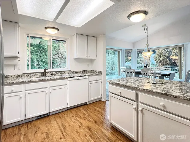 a kitchen with granite countertop white cabinets and white appliances