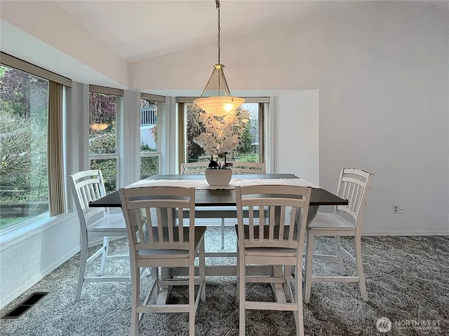 a dining room with furniture a chandelier and wooden floor