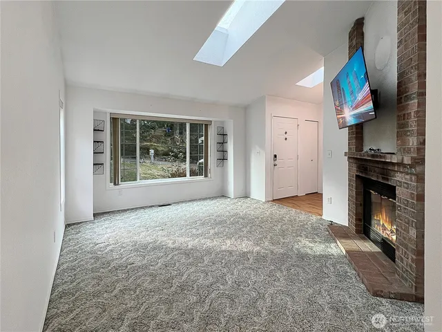 a view of an empty room with a fireplace and a window