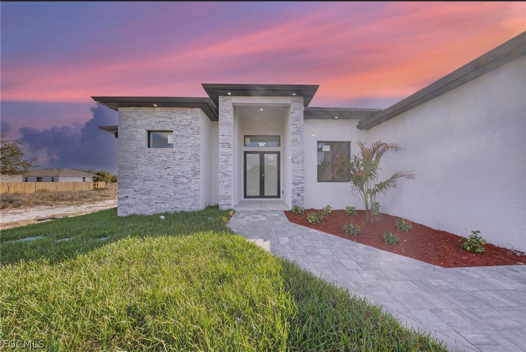 4013 12th Street Southwest Lehigh Acres, FL 33976 - Photo 2 of 29 a front view of a house with a yard and garage