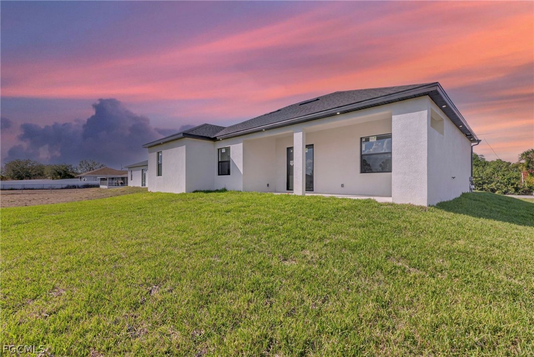 4013 12th Street Southwest Lehigh Acres, FL 33976 - Photo 26 of 29 a view of a house with a yard and a garage