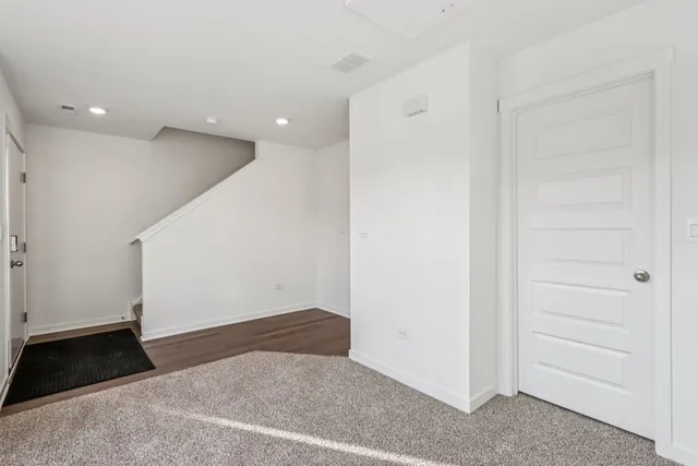 a view of empty room with wooden floor and window