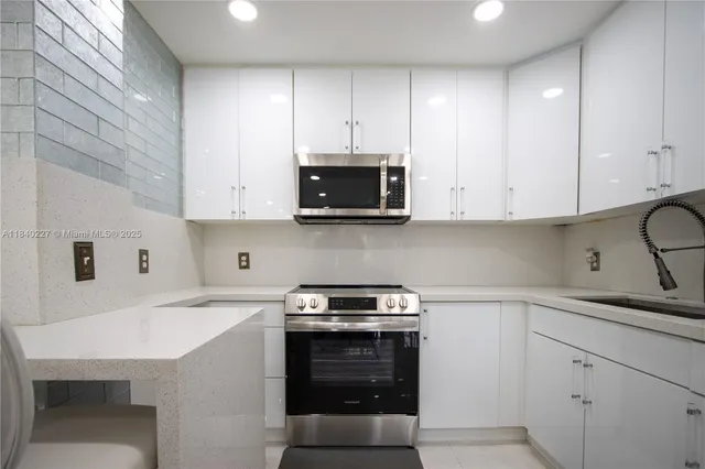 a kitchen with white cabinets and stainless steel appliances