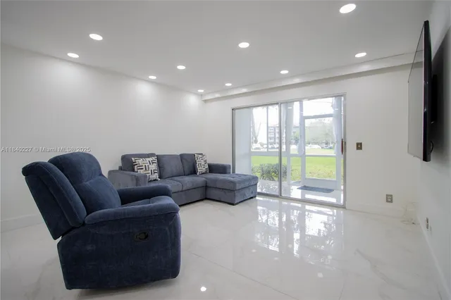 a living room with furniture and a floor to ceiling window