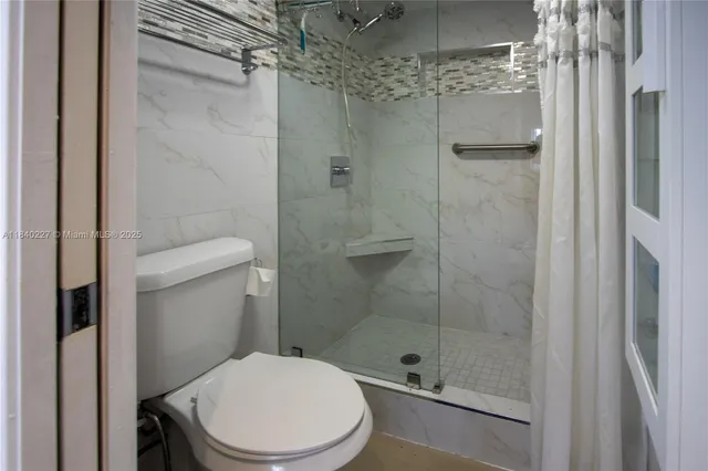 a white toilet next to a bathroom