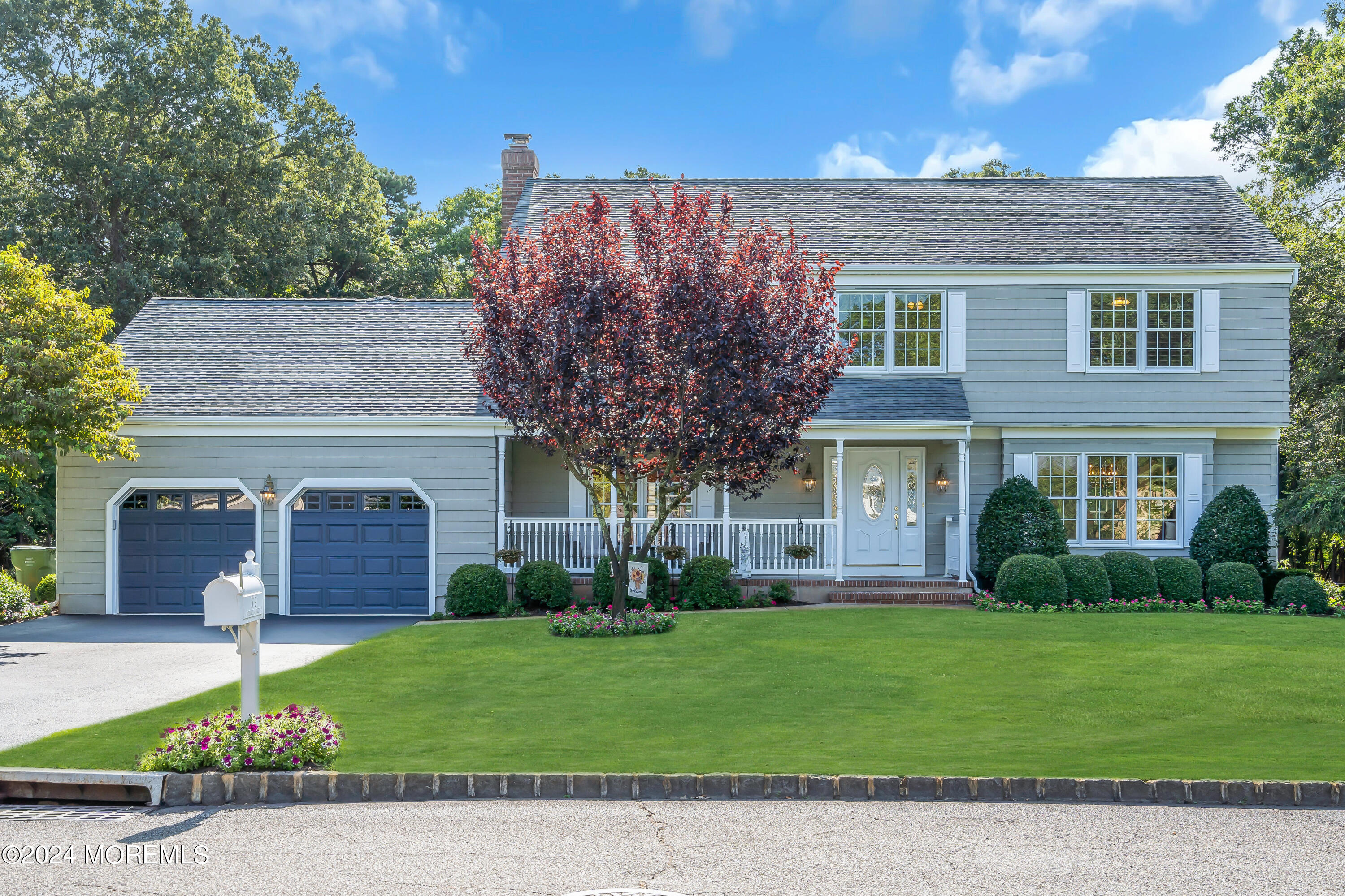 a front view of a house with a garden and yard