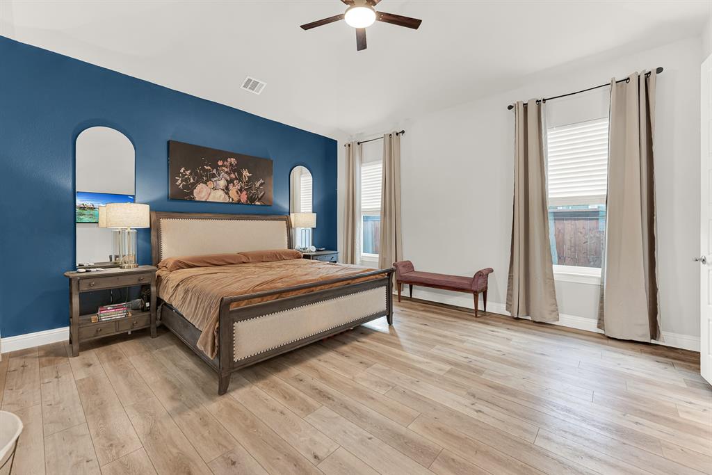 6404 Trezevant Street Rowlett, TX 75089 - Photo 17 of 30 a bedroom with a bed and a chandelier