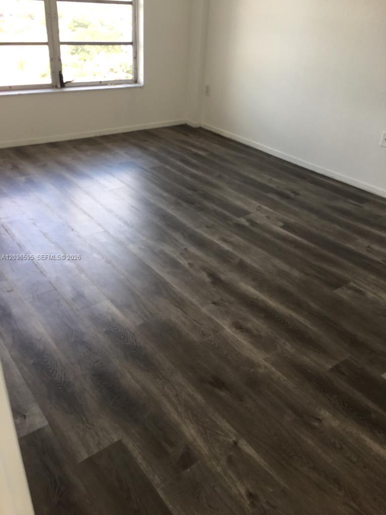 4164 Inverrary Drive, Unit 1004 Lauderhill, FL 33319 - Photo 9 of 15 an empty room with wooden floor and windows