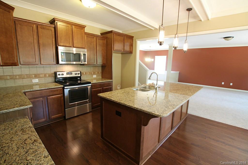 7140 Meyer Road, Unit 309 Fort Mill, SC 29715 - Photo 5 of 16 a kitchen with stainless steel appliances granite countertop a sink a stove and refrigerator