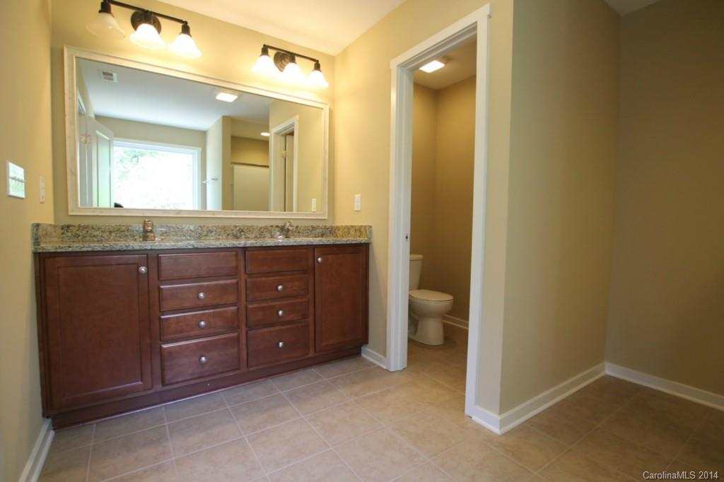 7140 Meyer Road, Unit 309 Fort Mill, SC 29715 - Photo 10 of 16 a bathroom with a granite countertop sink and a mirror