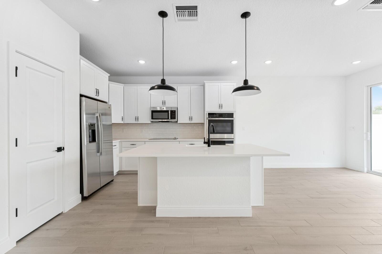 165 Southeast Birch Terrace, Unit 842 Stuart, FL 34997 - Photo 6 of 28 a view of a kitchen with kitchen island a sink stainless steel appliances and cabinets