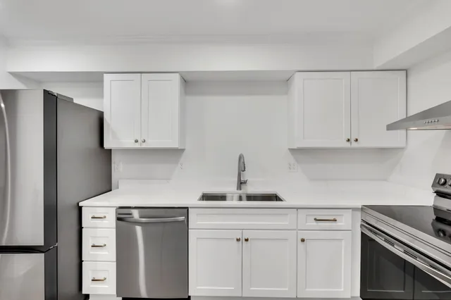 a kitchen with white cabinets and stainless steel appliances