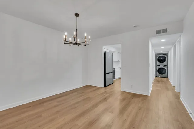a view of a room with wooden floor and a chandelier