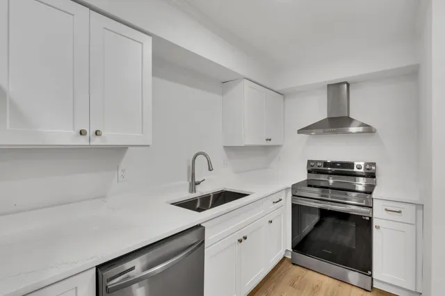 a kitchen with granite countertop white cabinets and stainless steel appliances