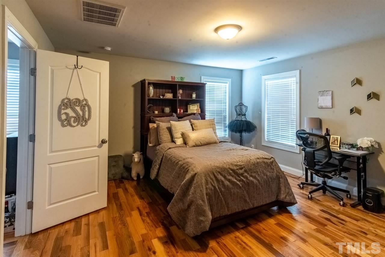 914 Chaney Road Raleigh, NC 27606 - Photo 12 of 15 a bedroom with a bed and wooden floor