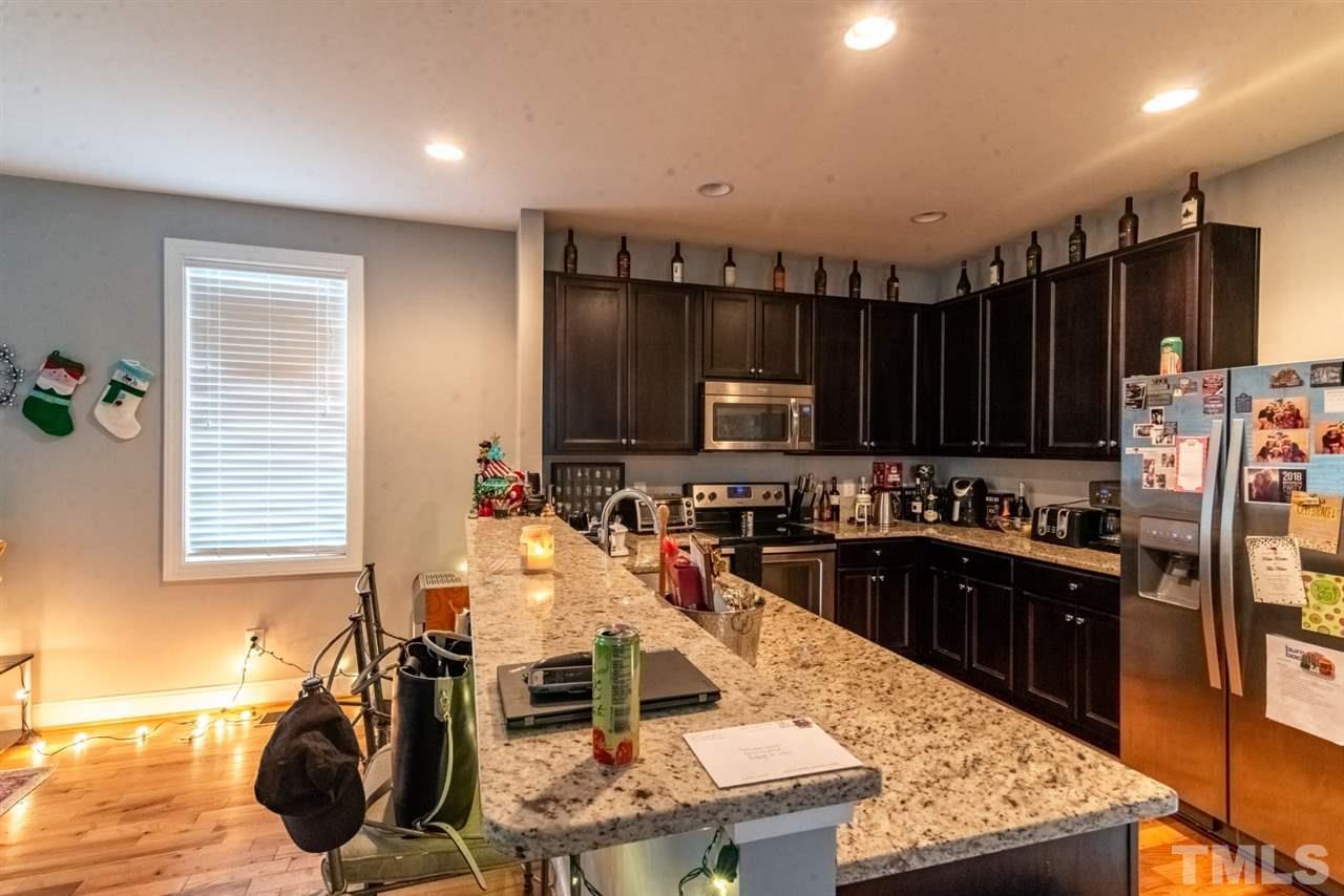 914 Chaney Road Raleigh, NC 27606 - Photo 4 of 15 a kitchen with stainless steel appliances granite countertop a stove top oven a sink dishwasher and cabinets with wooden floor
