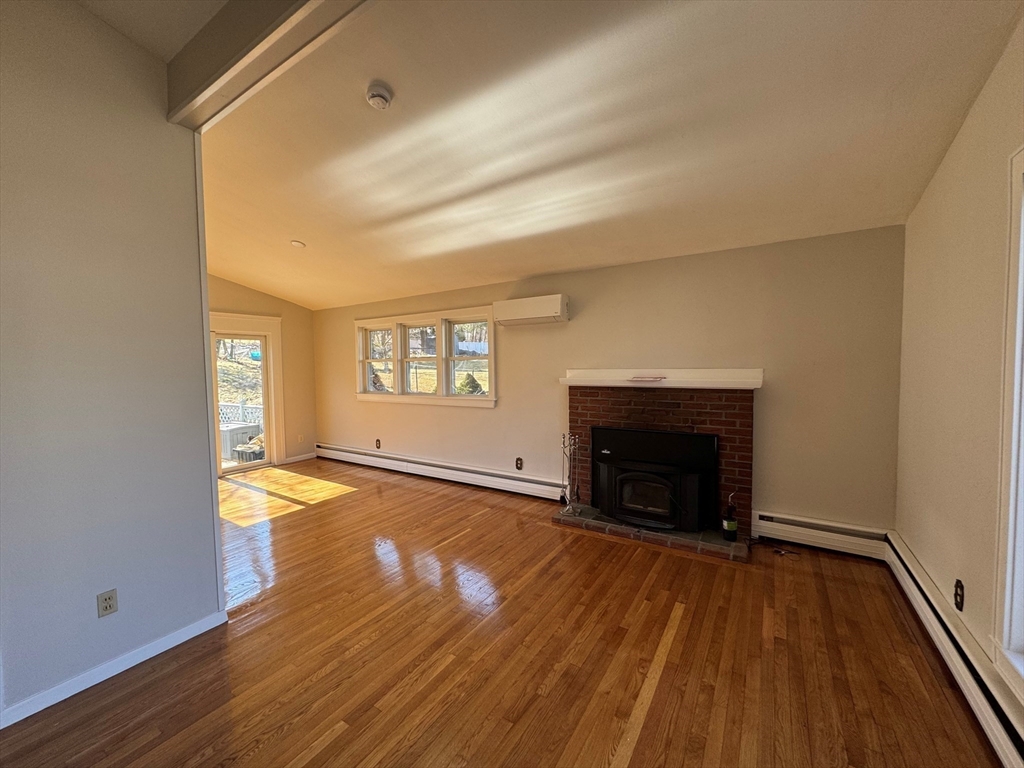 6 Redman Road Canton, MA 02021 - Photo 3 of 16 an empty room with wooden floor fireplace and windows