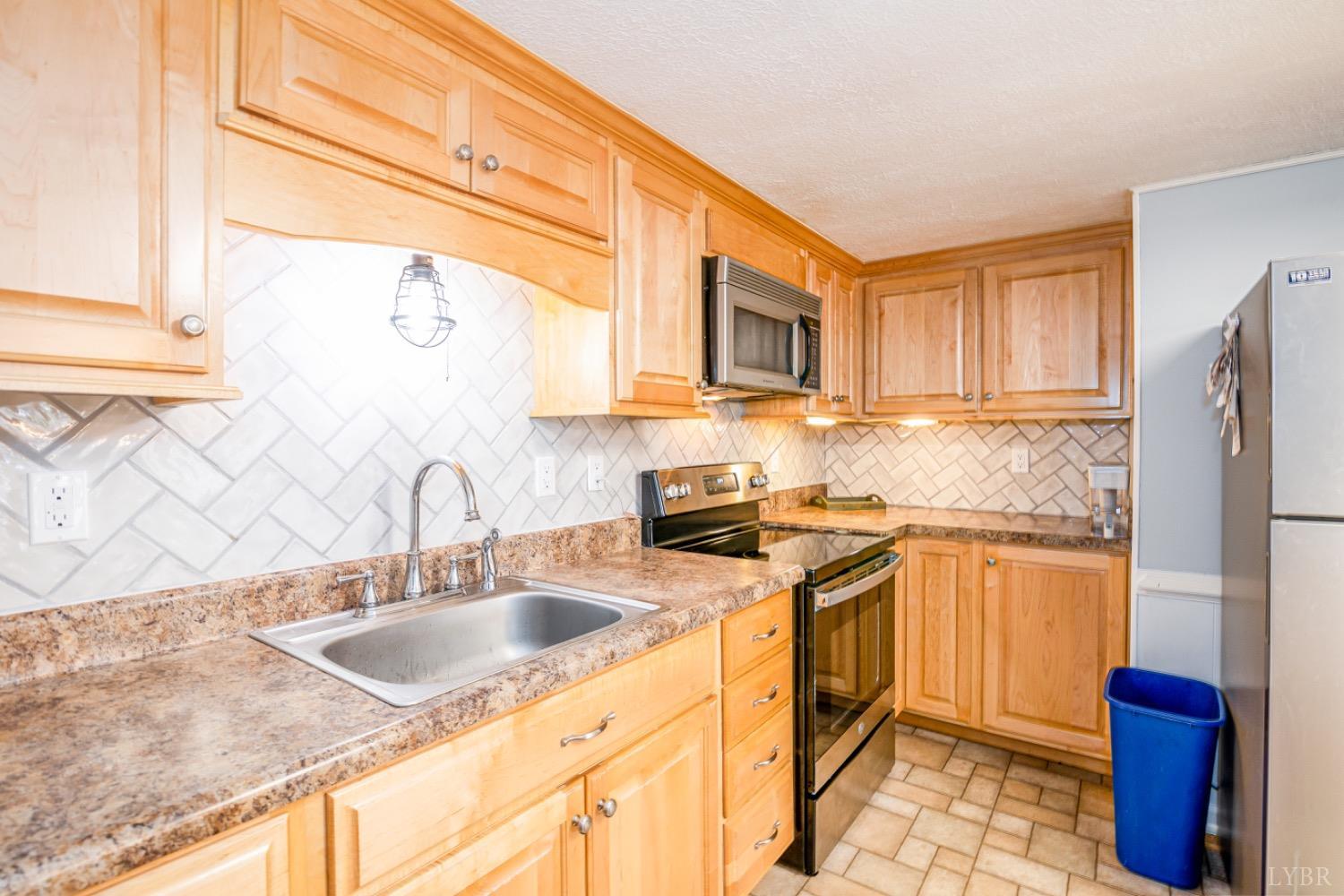 1097 Hummingbird Lane Spout Spring, VA 24593 - Photo 3 of 44 a kitchen with stainless steel appliances granite countertop a sink stove and refrigerator